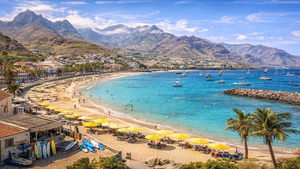 Plage du Cap-Vert avec sable doré, eau turquoise et montagnes volcaniques en arrière-plan, archipel tropical au large de l’Afrique de l’Ouest