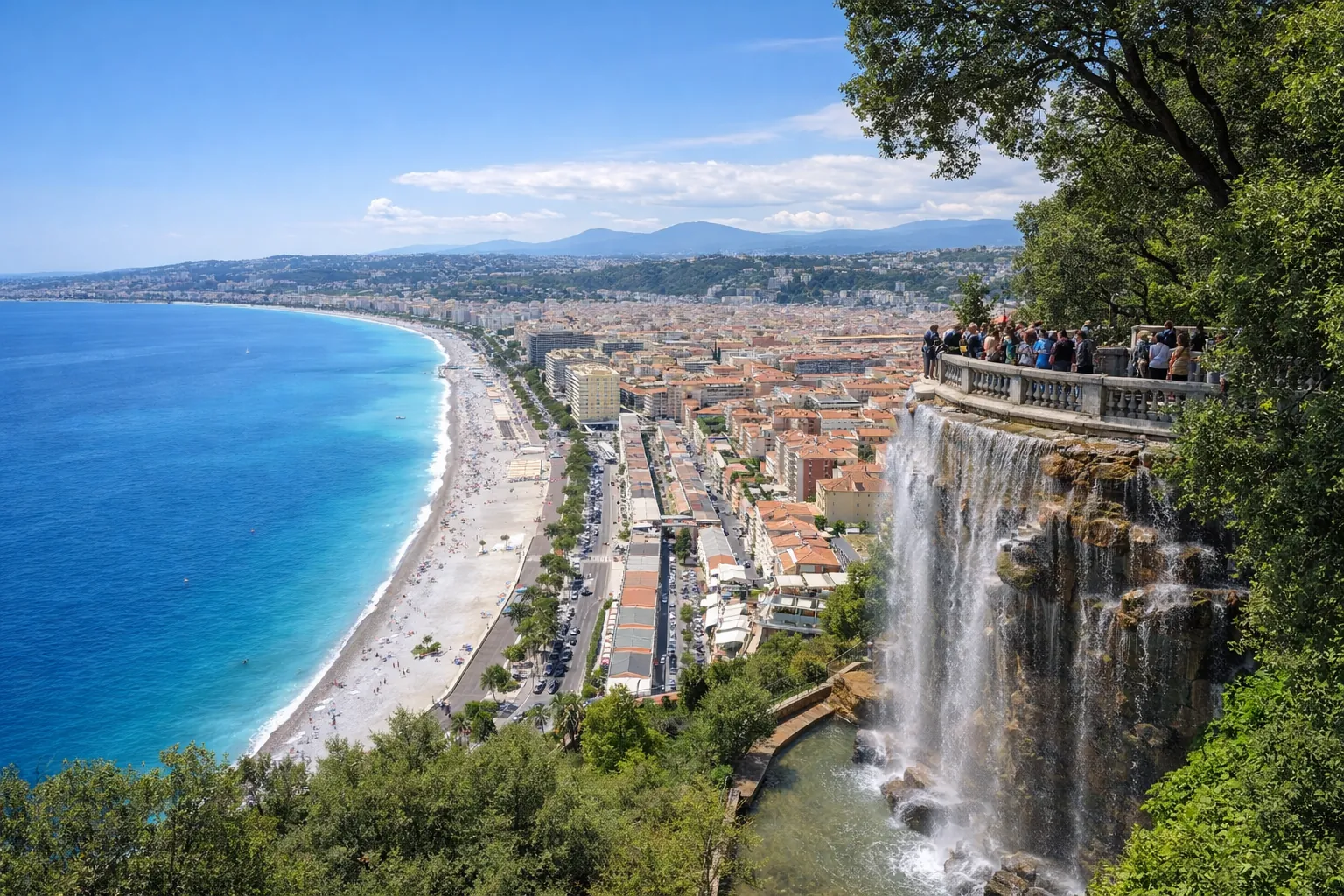 Vue panoramique depuis le parc de la colline du château à Nice, avec la Baie des Anges, la cascade du château, le Vieux-Nice et le littoral de la Côte d’Azur.