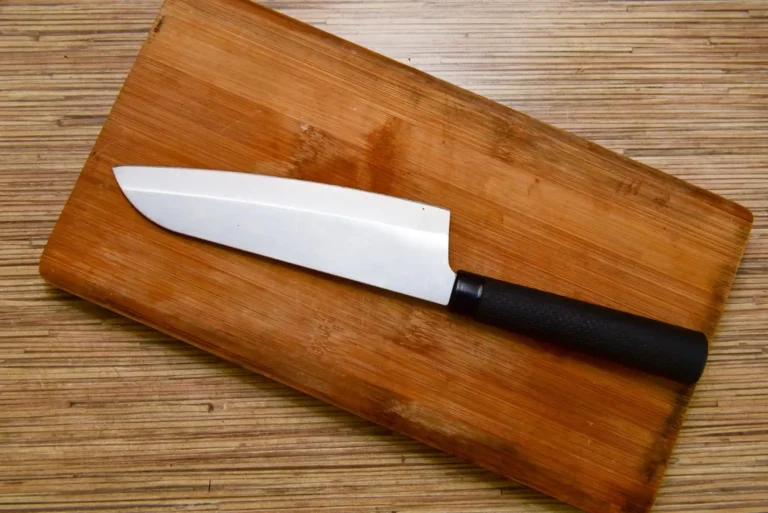 Comment bien choisir ses couteaux de cuisine ? 1 couteau de cuisine posé sur une planche à découper en bois sur un plan de travail