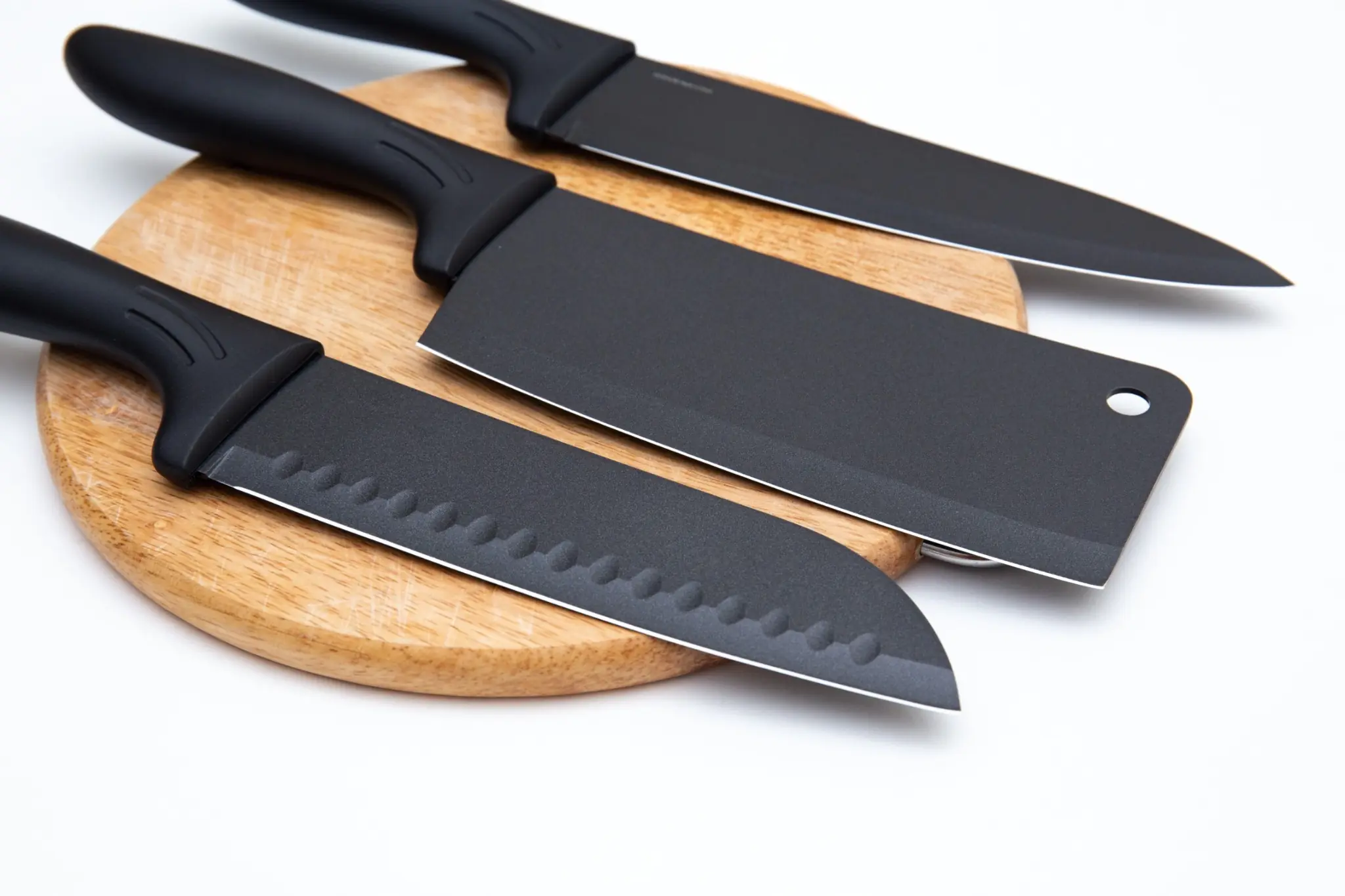Comment bien choisir ses couteaux de cuisine ? 2 couteaux de cuisine noirs posés sur une planche en bois pour préparer les ingrédients avec précision