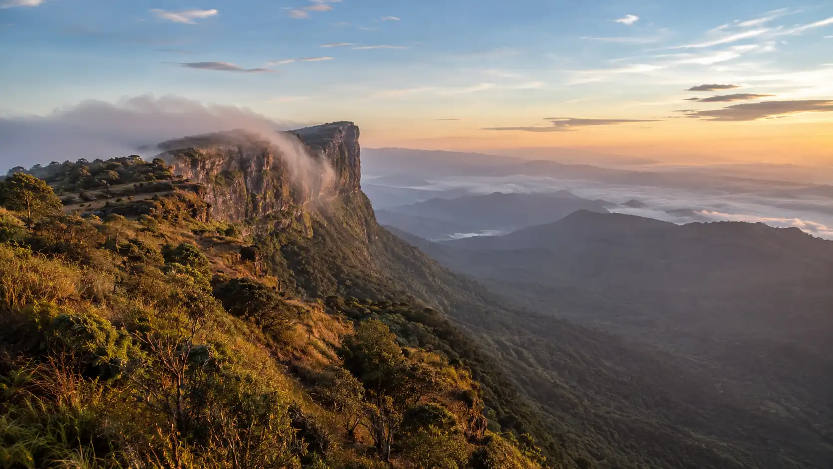 Vue panoramique de Horton Plains au Sri Lanka avec falaises, brume et montagnes au lever du soleil